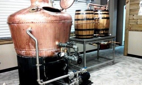 Micro brewery boiler system with copper kettle and polished piping.